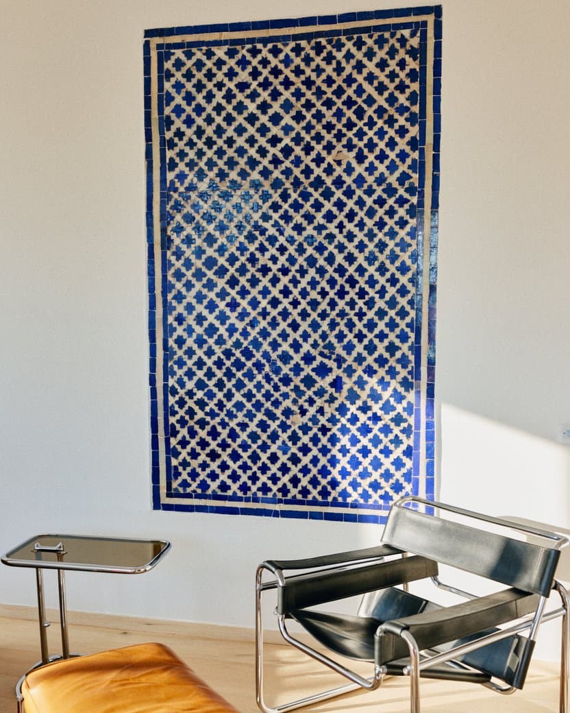 A bright sitting room with a cobalt zellige wall panel behind a leather sofa — after