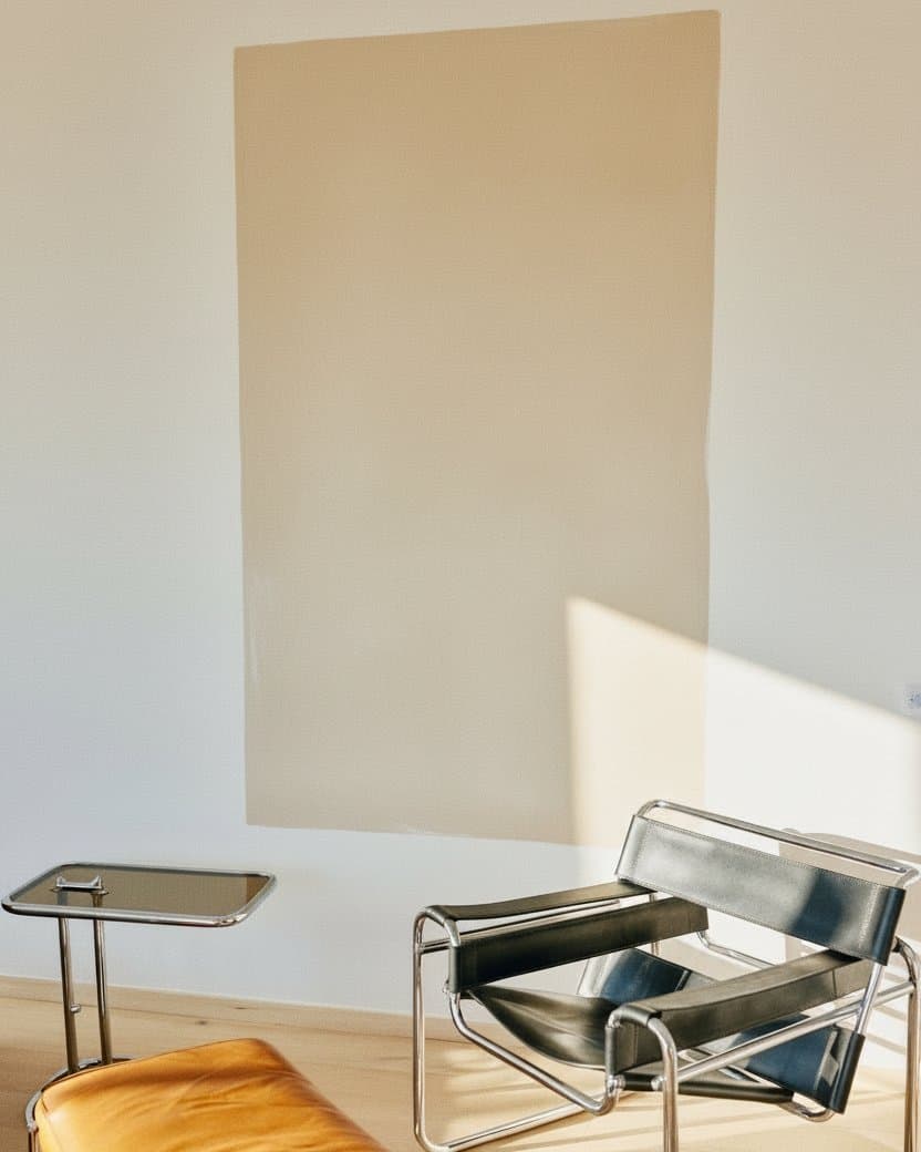 A bright sitting room with a cobalt zellige wall panel behind a leather sofa — before