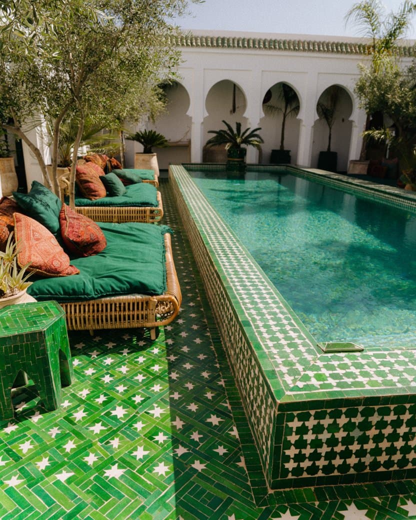 An emerald and white zellige lap pool in a plain-walled riad courtyard — after